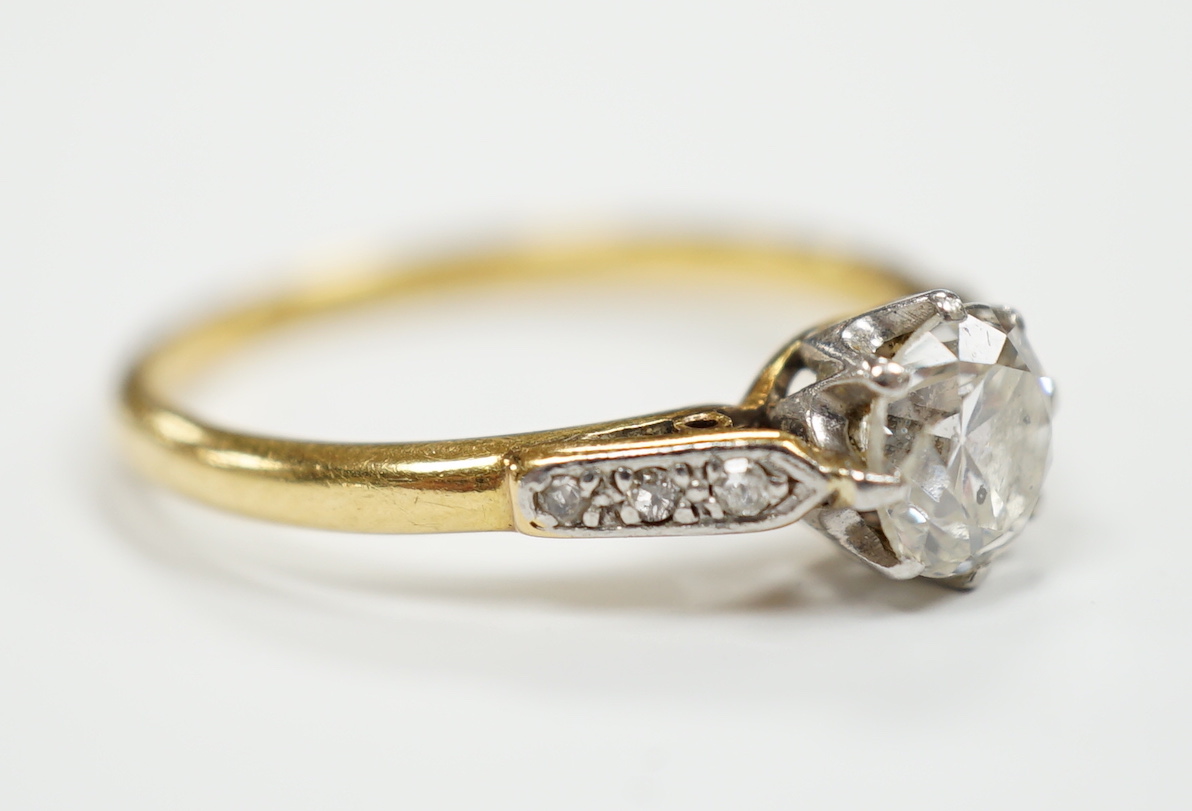 An 18ct, plat. and single stone diamond ring, with diamond set shoulders, the central stone measuring 6mm in diameter.